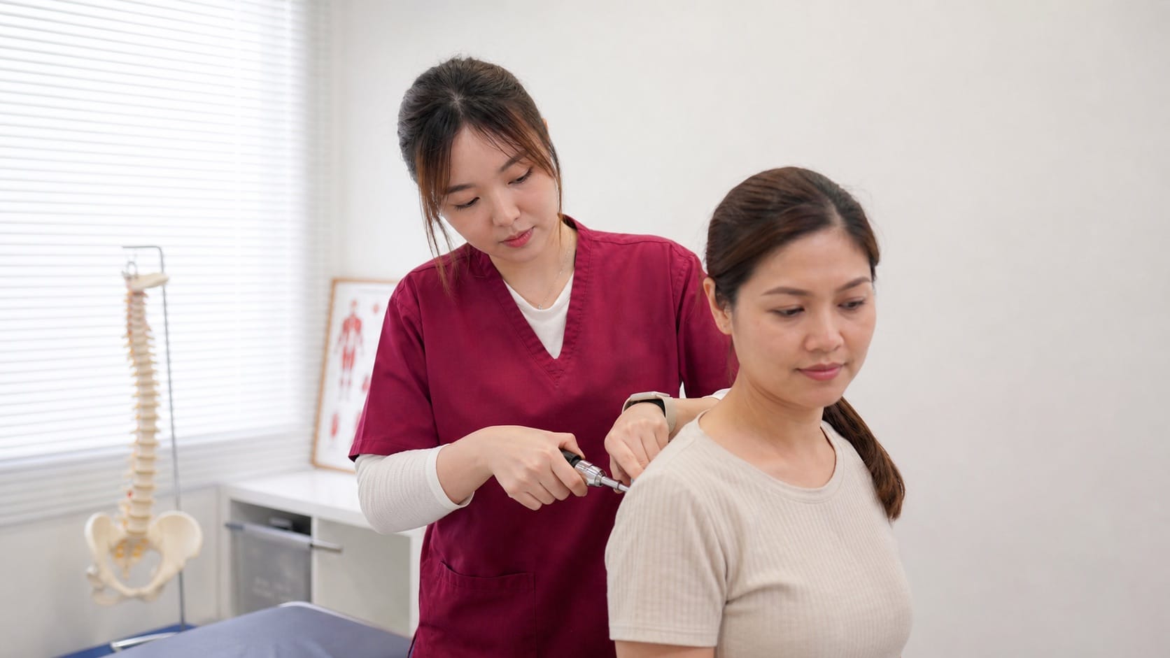 Ivy from One Spine demonstrating a low-force Activator chiropractic method in clinic