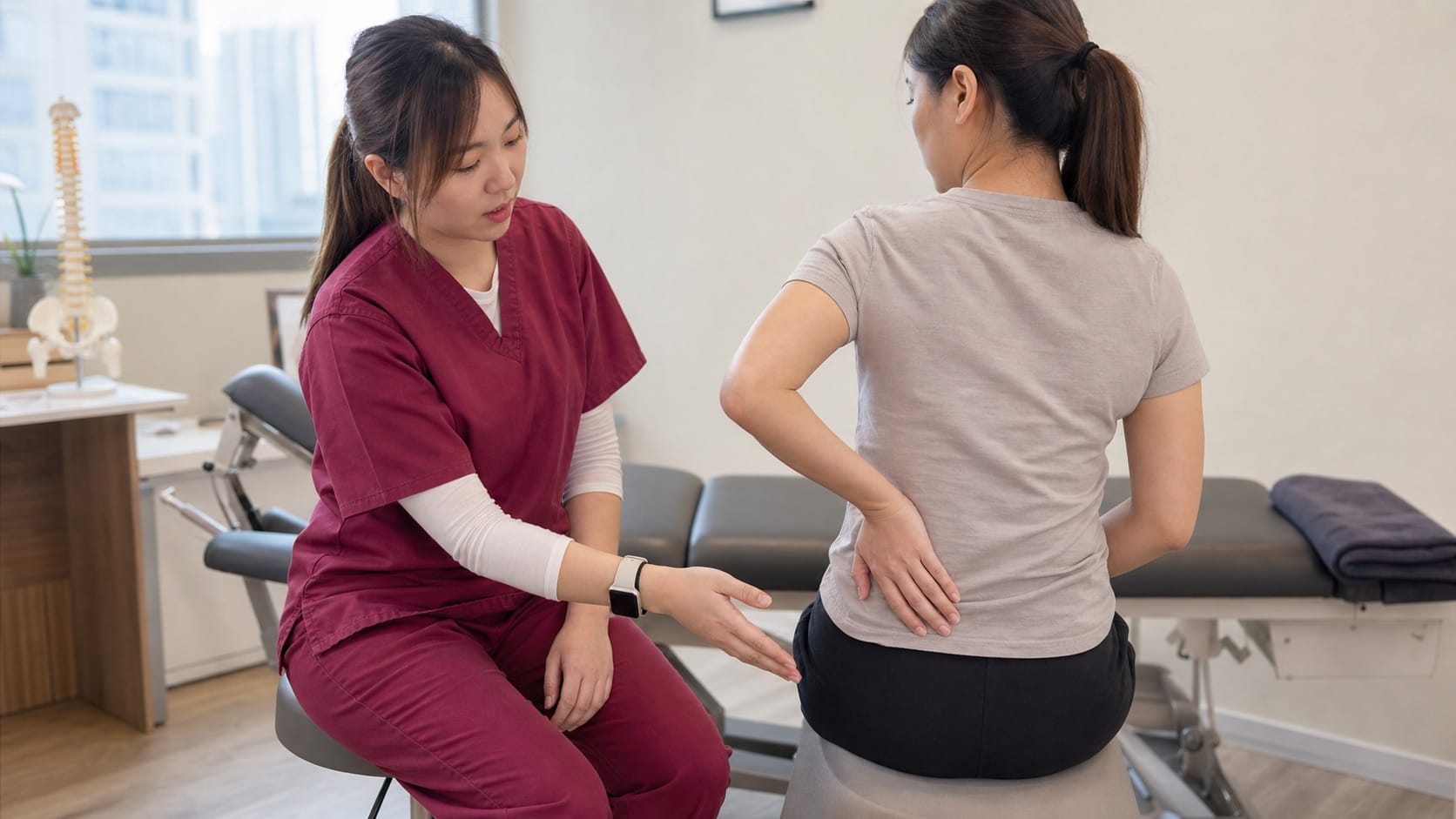 Ivy from One Spine explaining sitting posture and tailbone pain in a clinic setting